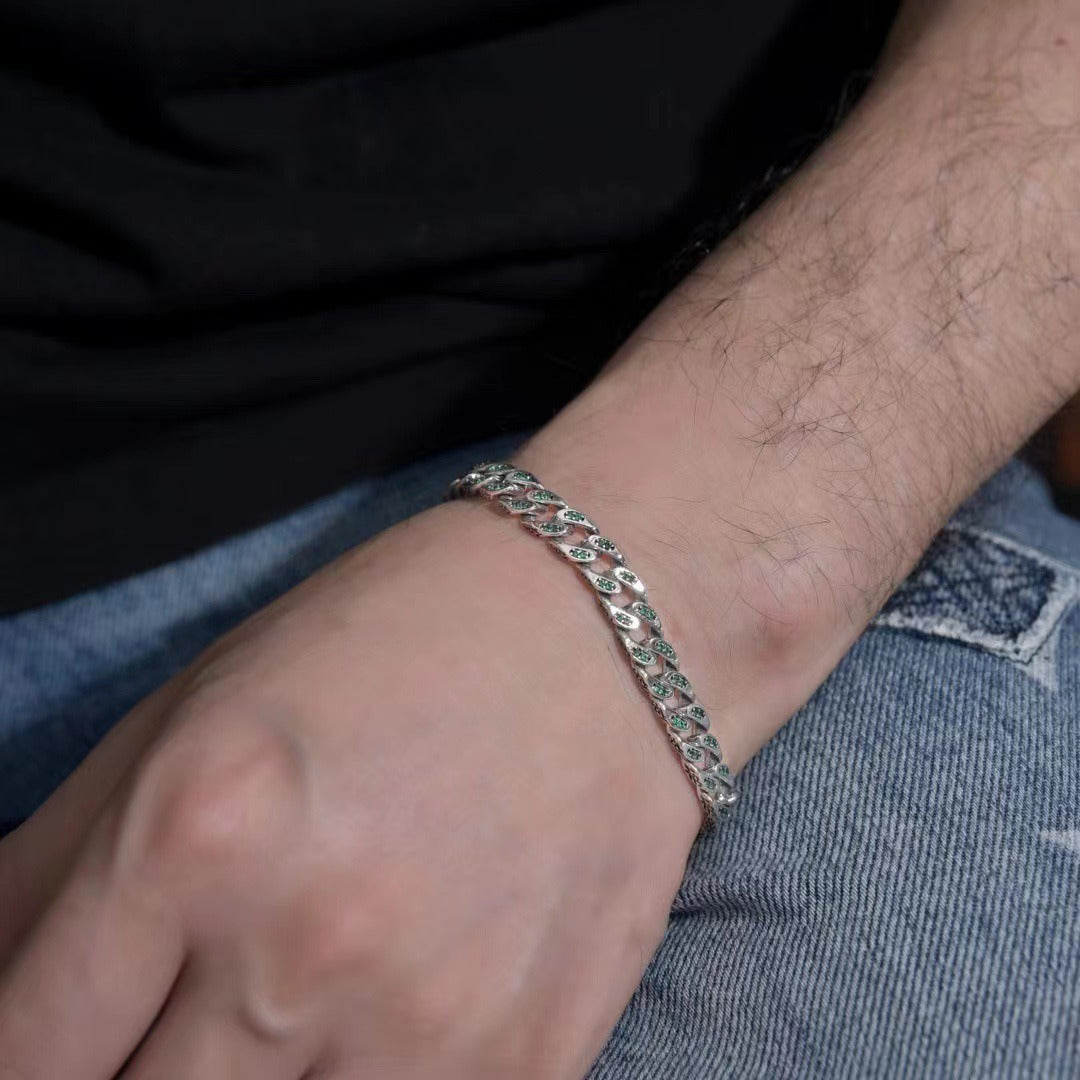 Close-up of a person's wrist wearing a silver bracelet with green stones.