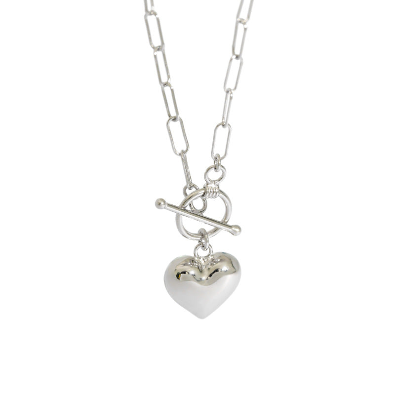 Silver heart-shaped pendant on a chain against a white background