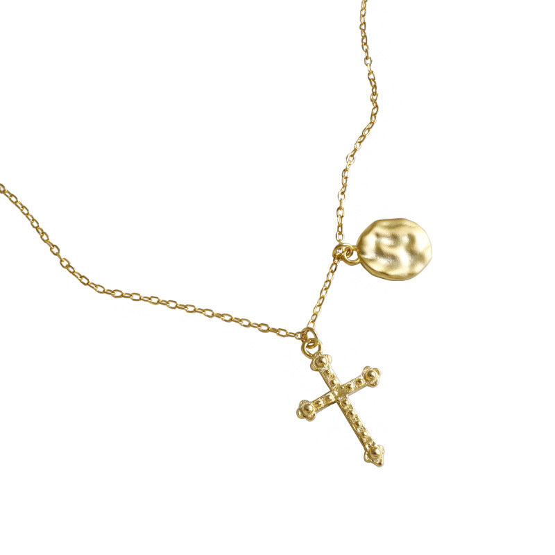 Gold necklace with a cross pendant on a white background