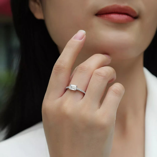 Close-up of a hand wearing a diamond ring with a blurred background