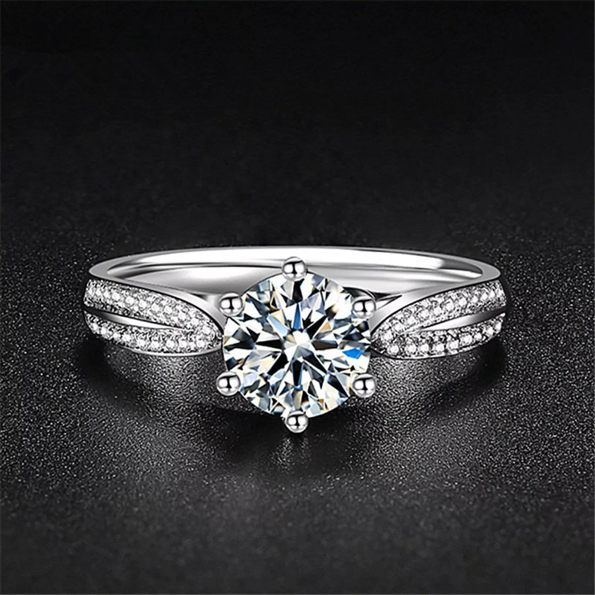 Silver ring with a large diamond on a dark background