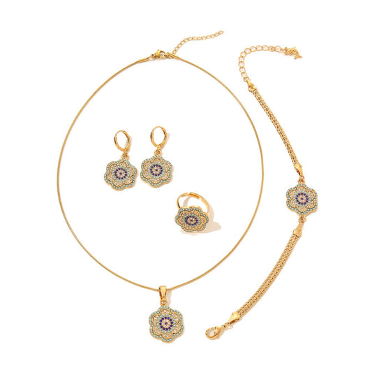 Gold-tone flower jewelry set featuring a blue enamel evil eye necklace, bracelet, and matching drop earrings on a white background.