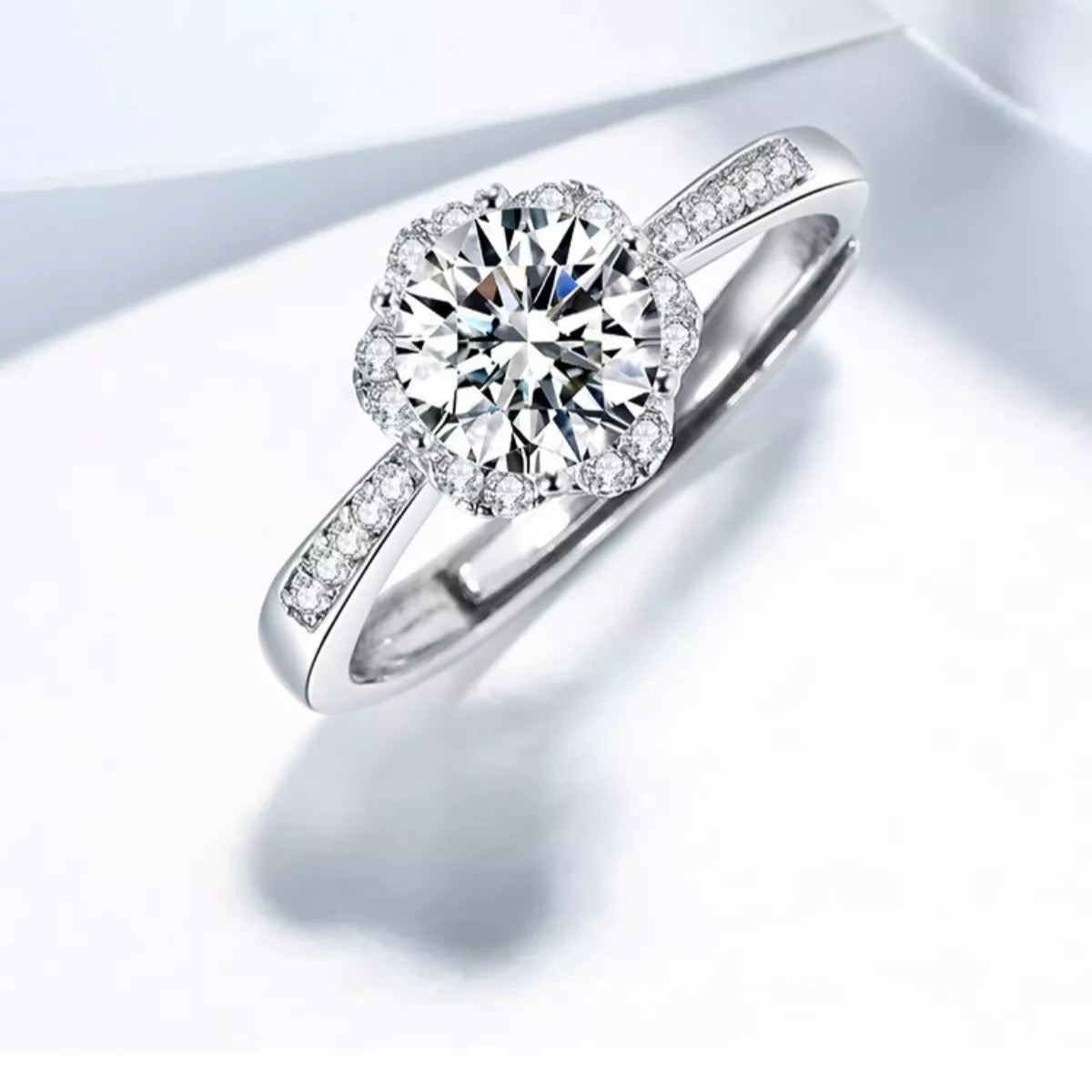 Silver ring with a large diamond and smaller diamonds on the band against a light background