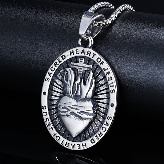 Silver 'Sacred Heart of Jesus' pendant on a black background