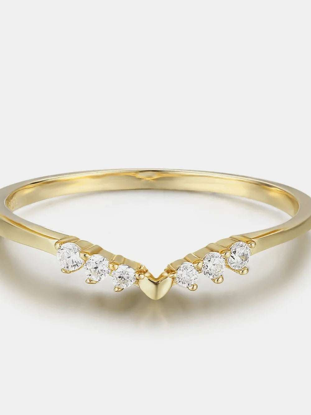 Gold ring with small diamonds on a light background