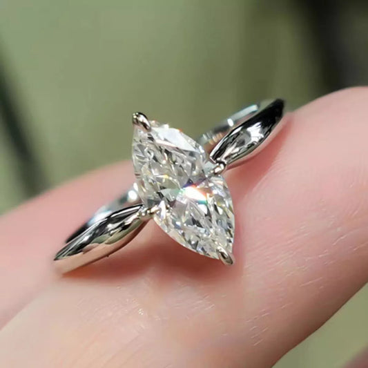 Silver ring with a large diamond on a finger against a blurred background