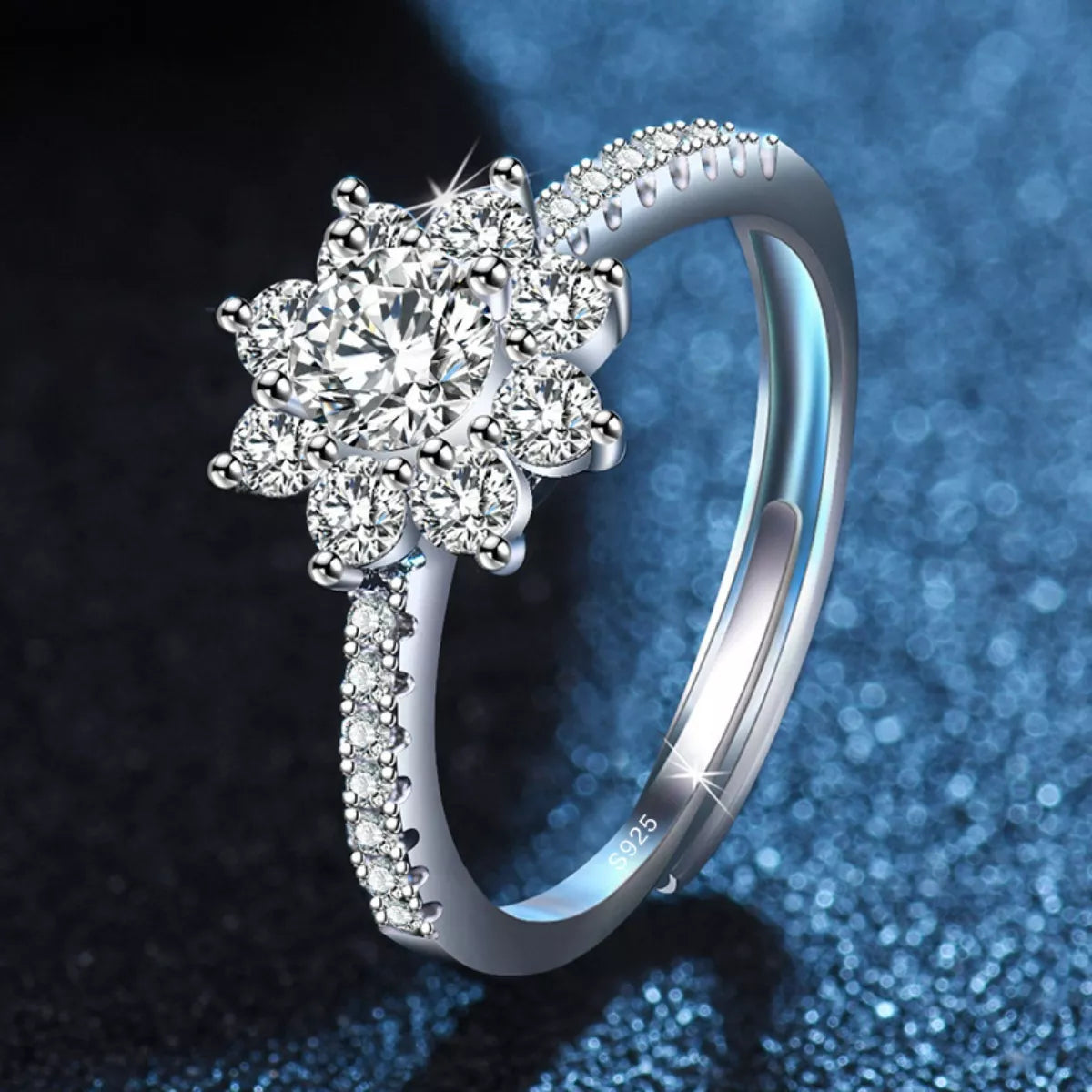 Silver ring with diamond-like stones on a dark blue gradient background