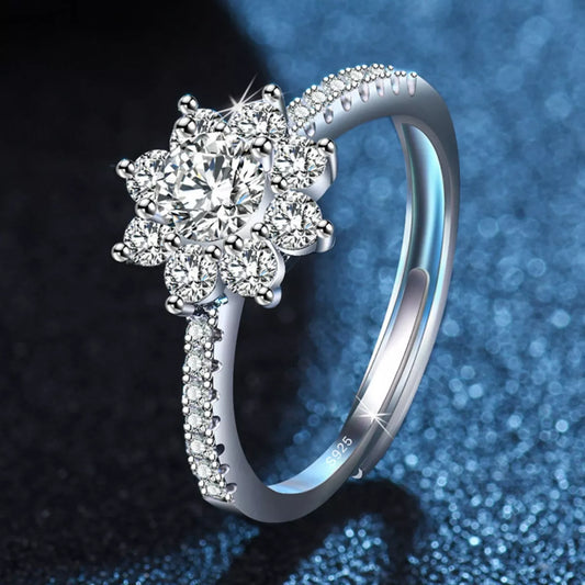 Silver ring with diamond-like stones on a dark blue gradient background