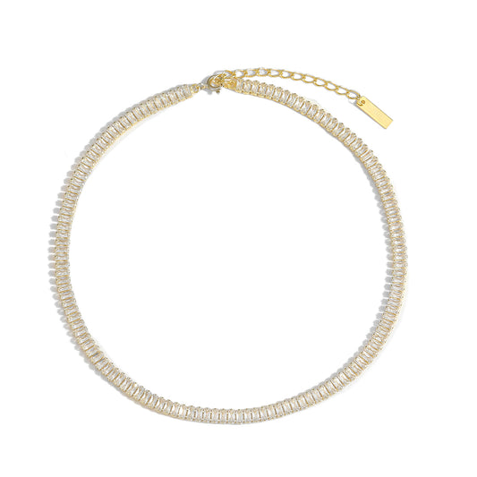 Gold necklace with clear gemstones on a white background