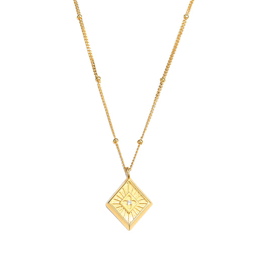 Gold necklace with a geometric pendant on a white background