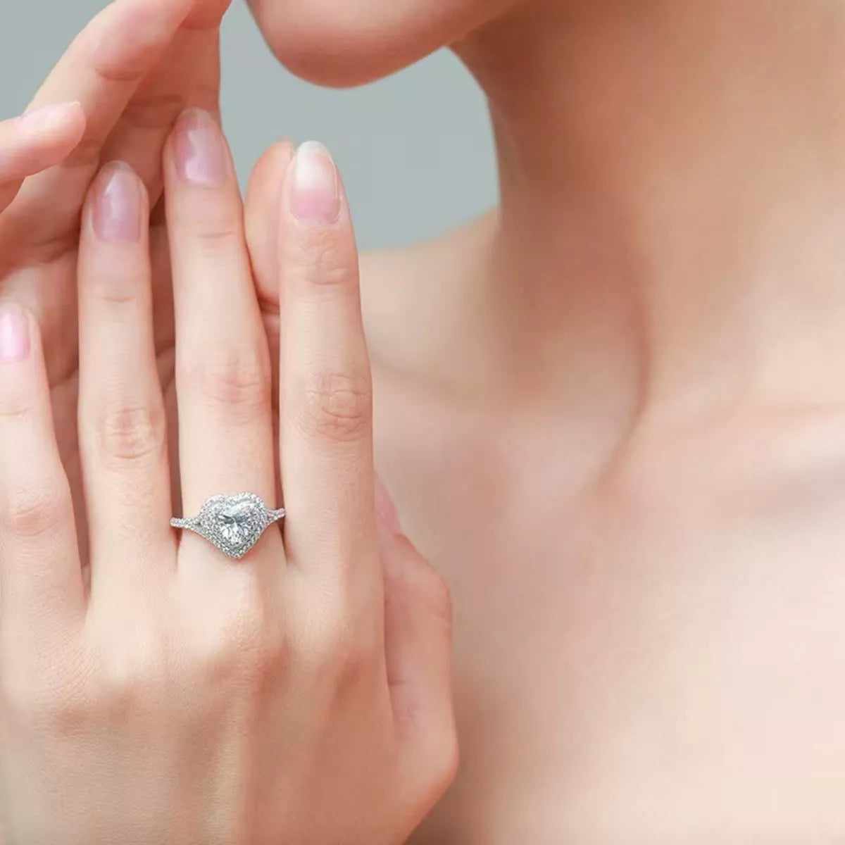Close-up of a hand wearing a diamond ring with a blurred background