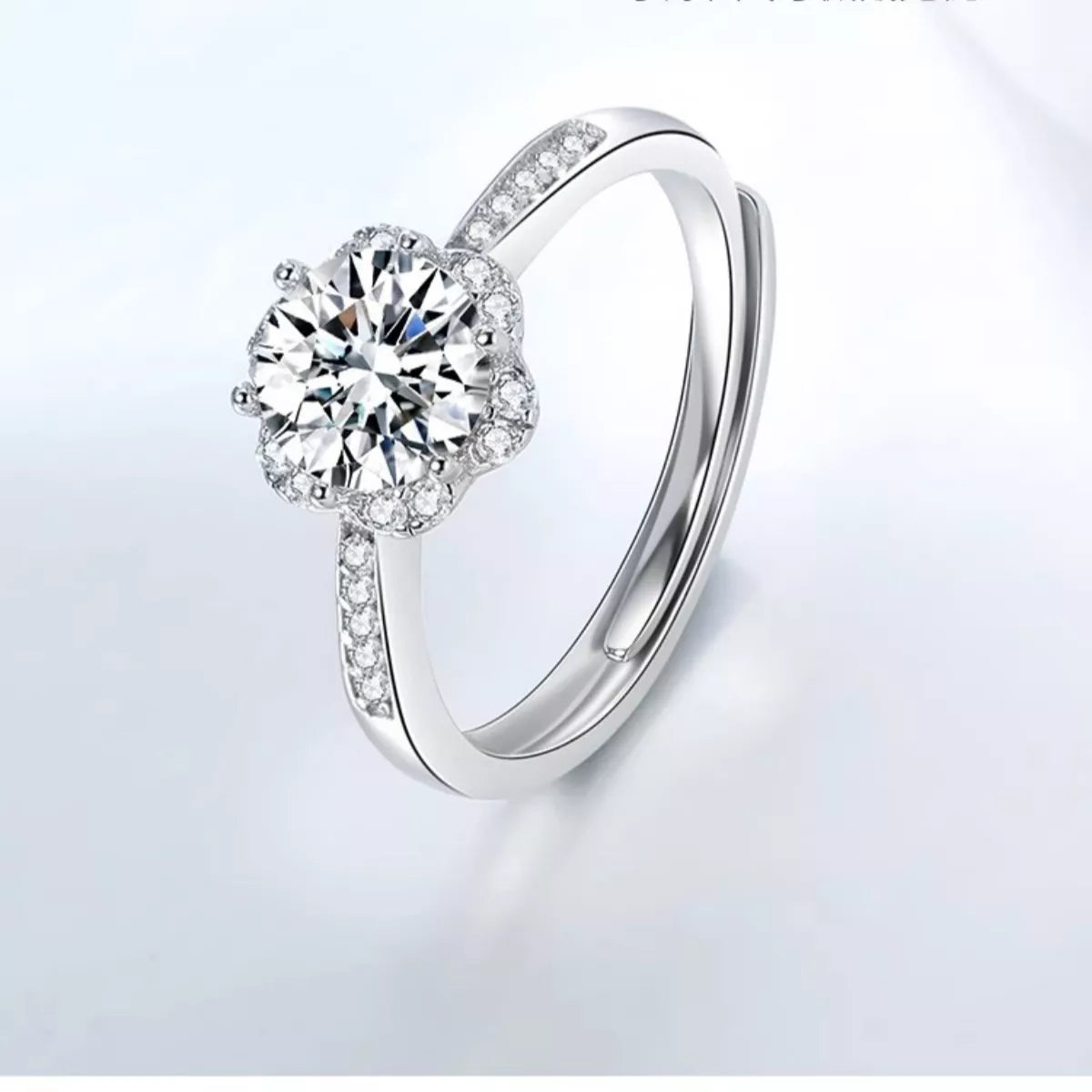 Silver ring with a large diamond and smaller diamonds on a light gray background