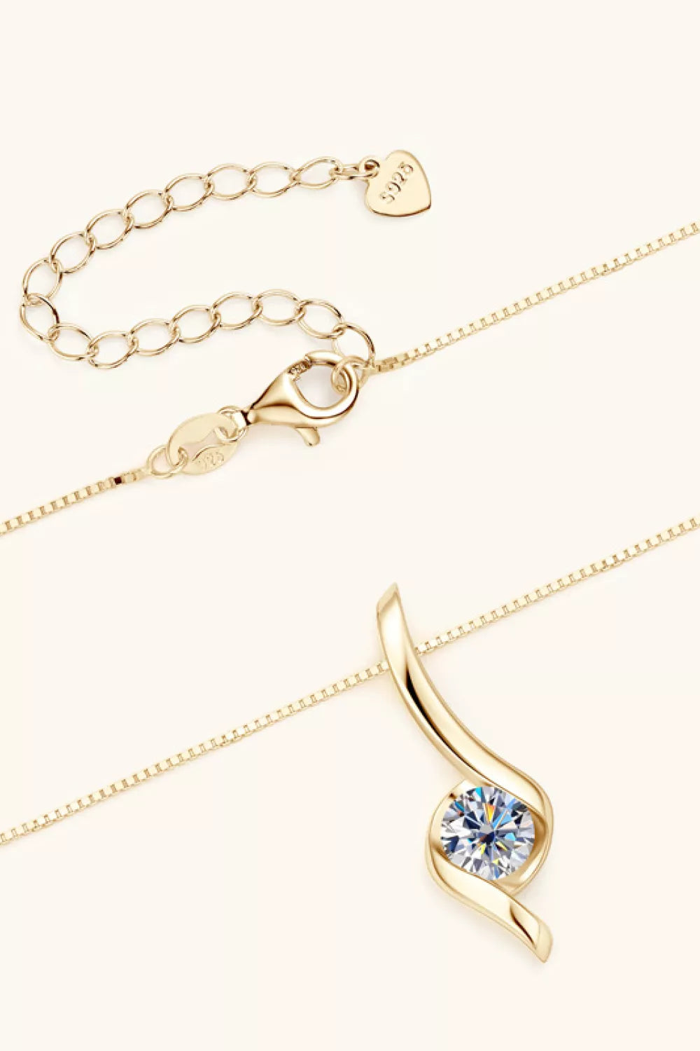 Gold necklace with a blue gemstone pendant on a white background