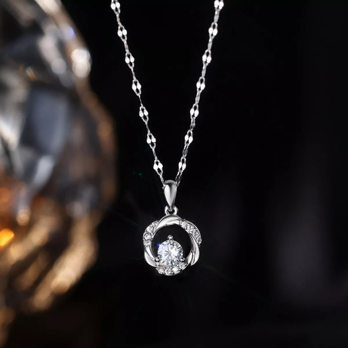 Silver necklace with a pendant on a dark background