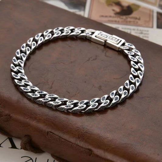 Silver chain bracelet on a textured brown surface