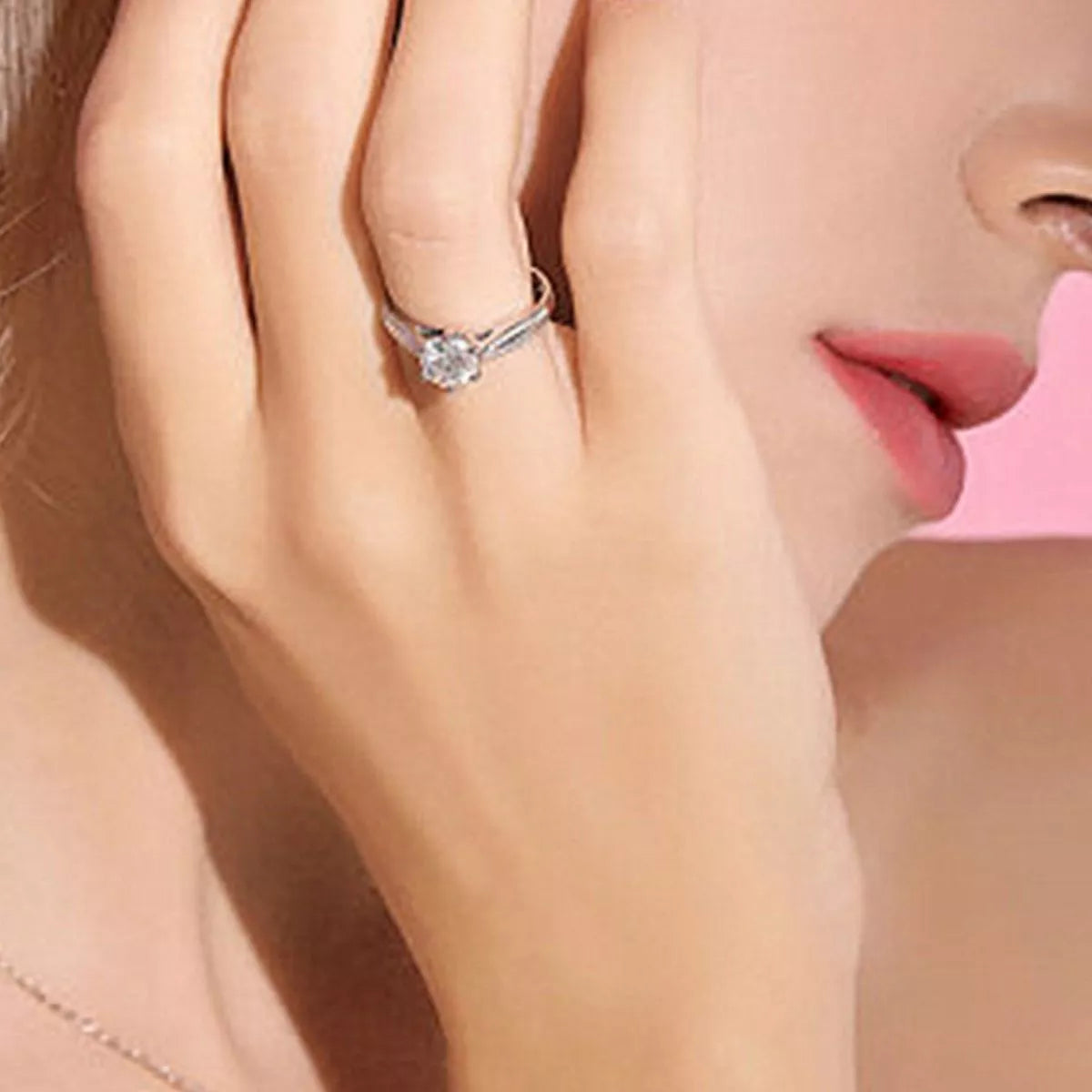 Close-up of a hand wearing a diamond ring with a blurred background