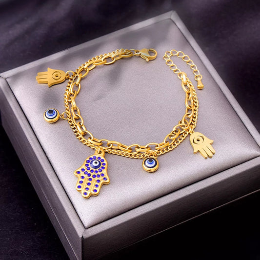 Gold bracelet with charms on a gray box
