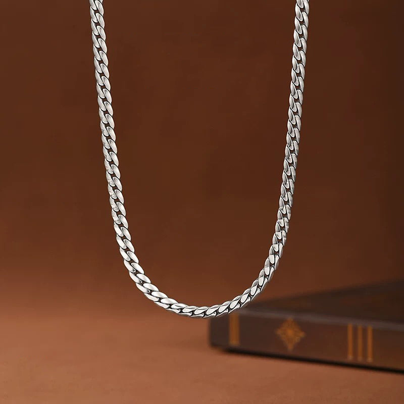 Silver chain necklace on a brown background