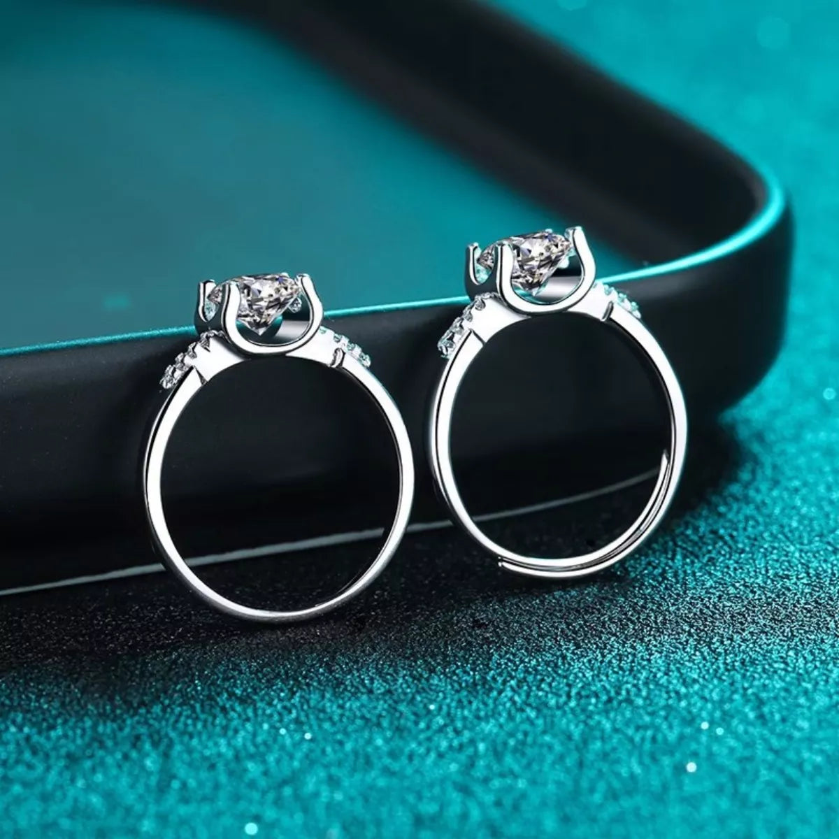 Pair of silver hoop earrings on a teal background