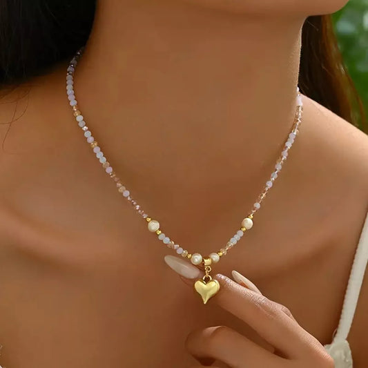 Necklace with a heart pendant worn by a person, with a blurred background