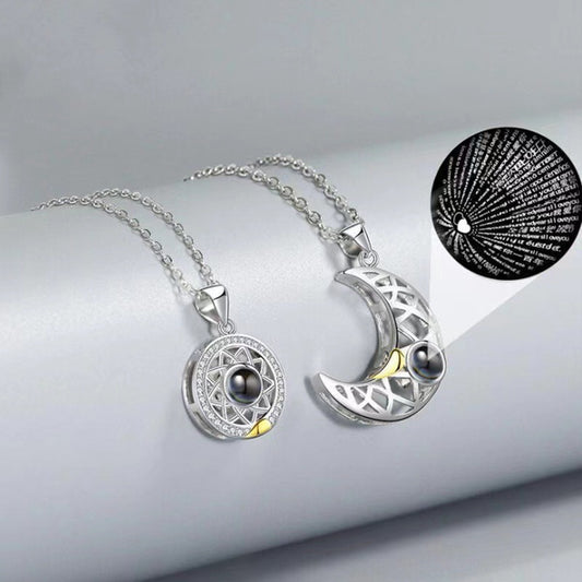 Silver necklace with moon and circle pendants on a light gray background