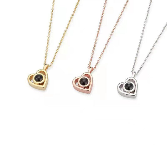 Three heart-shaped pendants on gold, rose gold, and silver chains against a white background.