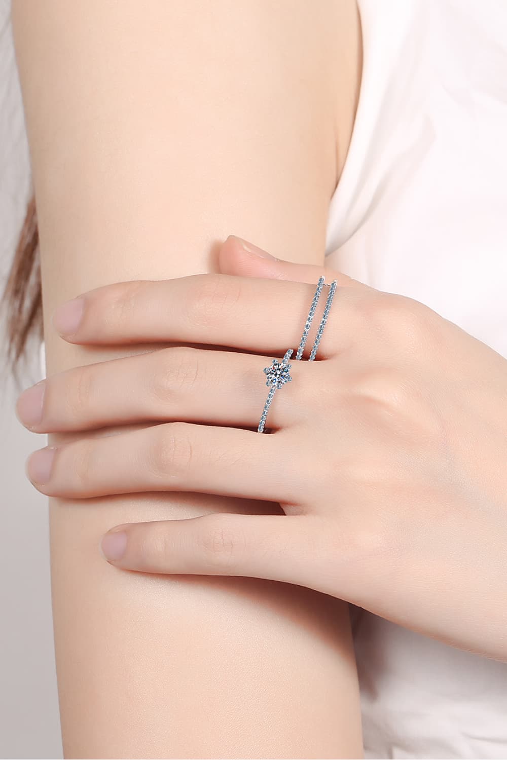 Close-up of a Moissanite 925 Sterling Silver Ring Set featuring a delicate round solitaire ring and a matching pavé band stacked on a hand | Le'Var Neilson Jewelry