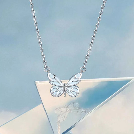 Silver butterfly necklace on a light blue background