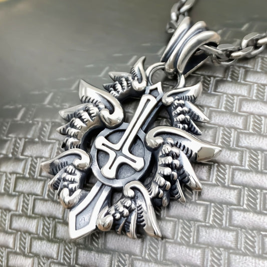 Silver cross pendant with detailed design on a textured metal surface