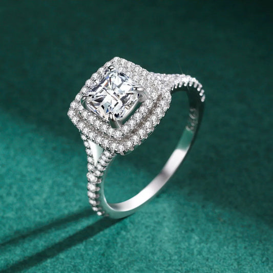 Silver ring with a large diamond and smaller diamonds on a green background