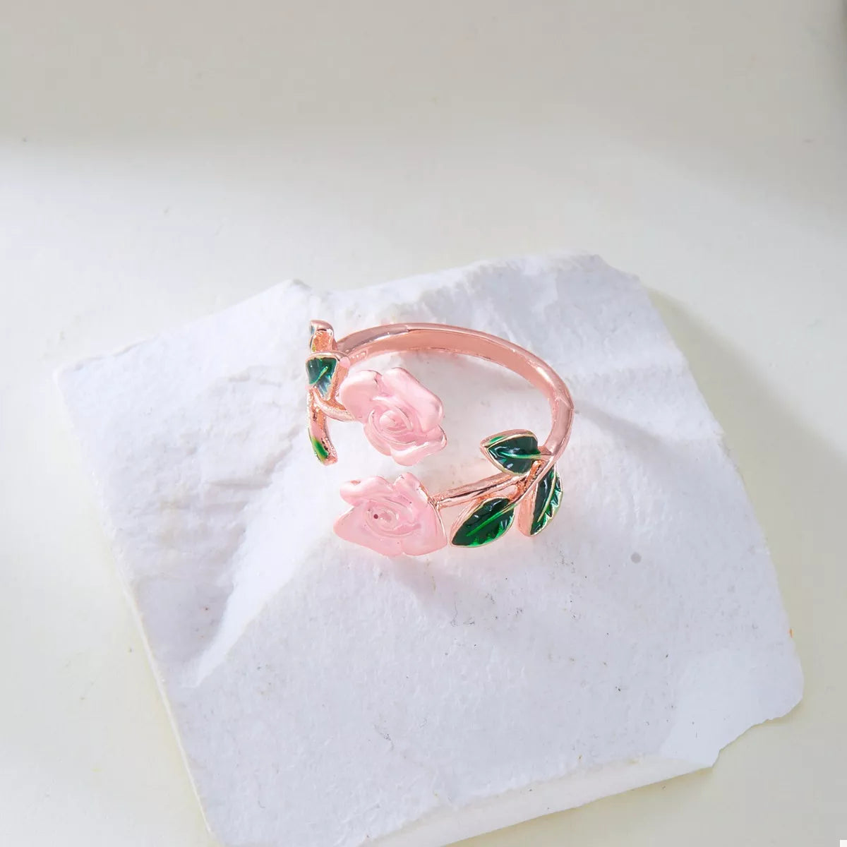 Rose gold bracelet with pink roses on a white fabric background