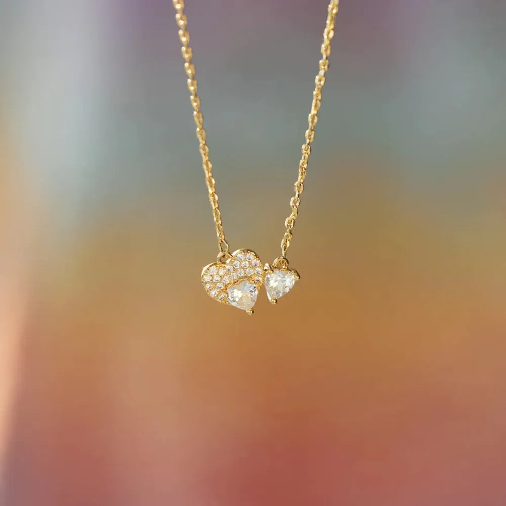 Gold necklace with heart-shaped pendant on a blurred background