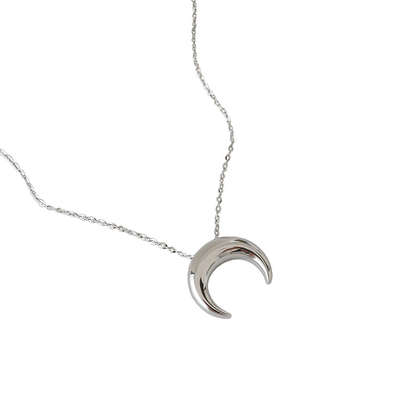 Silver crescent moon necklace on a white background