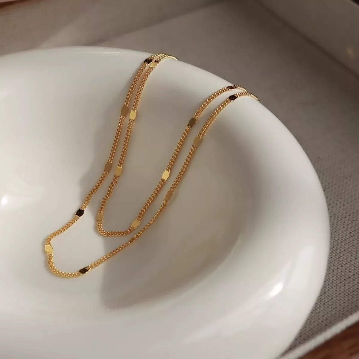 Gold necklace on a white ceramic dish