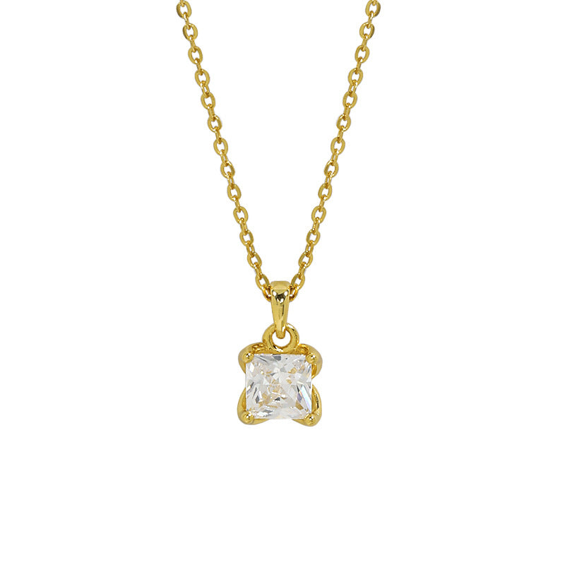 Gold necklace with a clear gemstone pendant on a white background