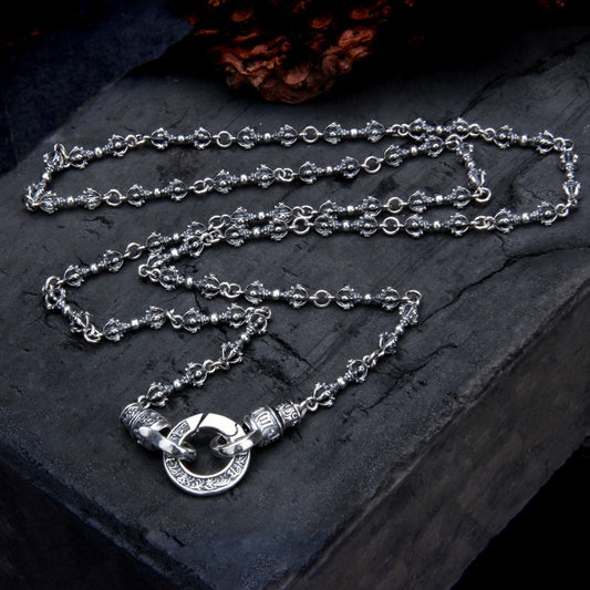 Silver chain necklace on a dark stone surface