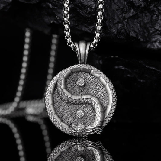 Silver yin-yang pendant on a dark background
