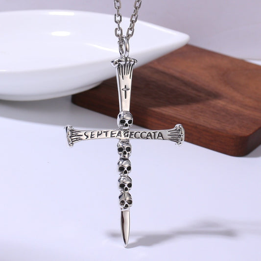 Silver cross necklace with skull design on a white background
