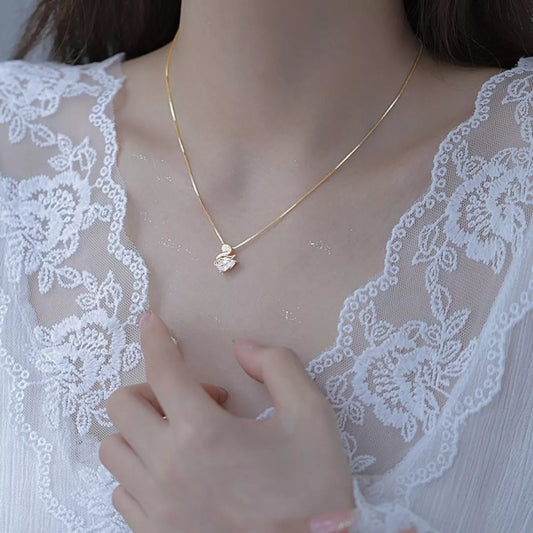 Gold necklace on a person wearing a white lace garment