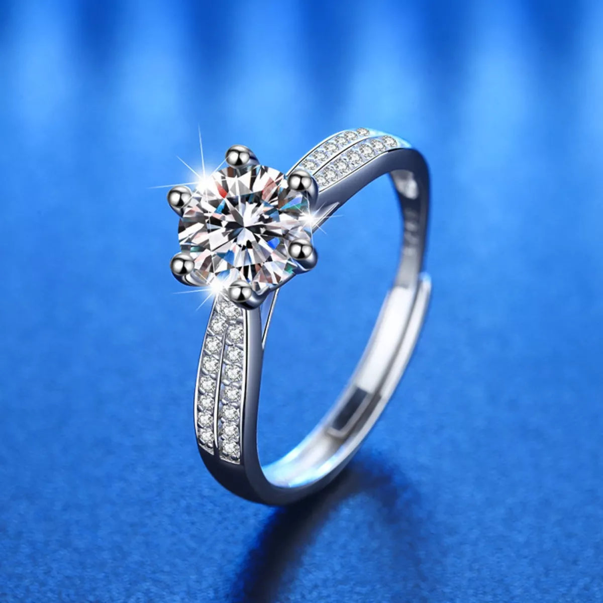 Silver ring with a large central gemstone on a blue background
