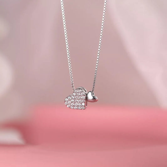 Necklace with heart-shaped pendants on a pink background