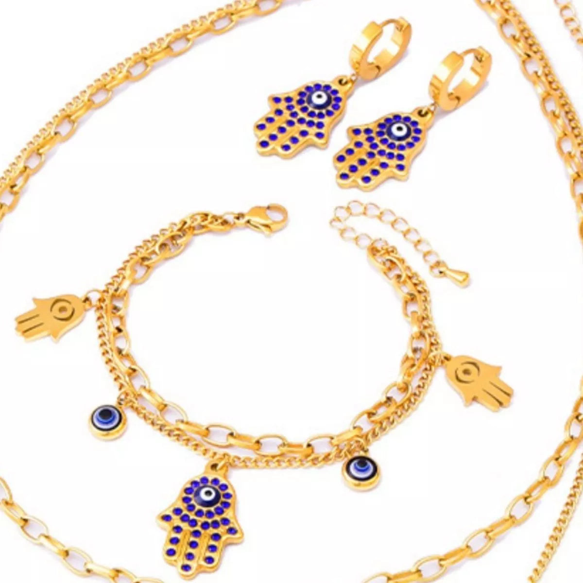 Gold jewelry set with Hamsa hand and evil eye charms on a white background