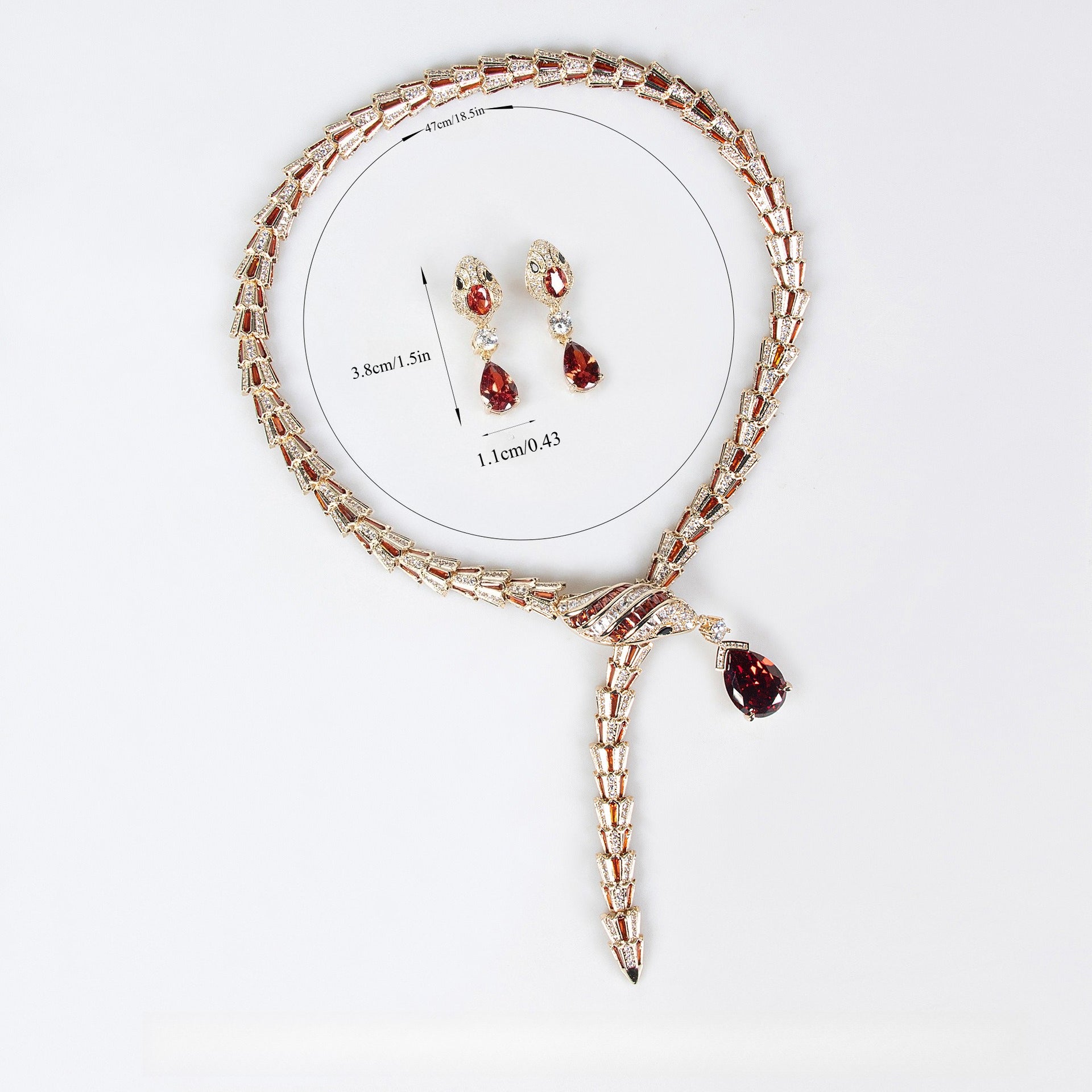 Gold snake necklace and earrings set with red and clear stones, featuring product measurement details.