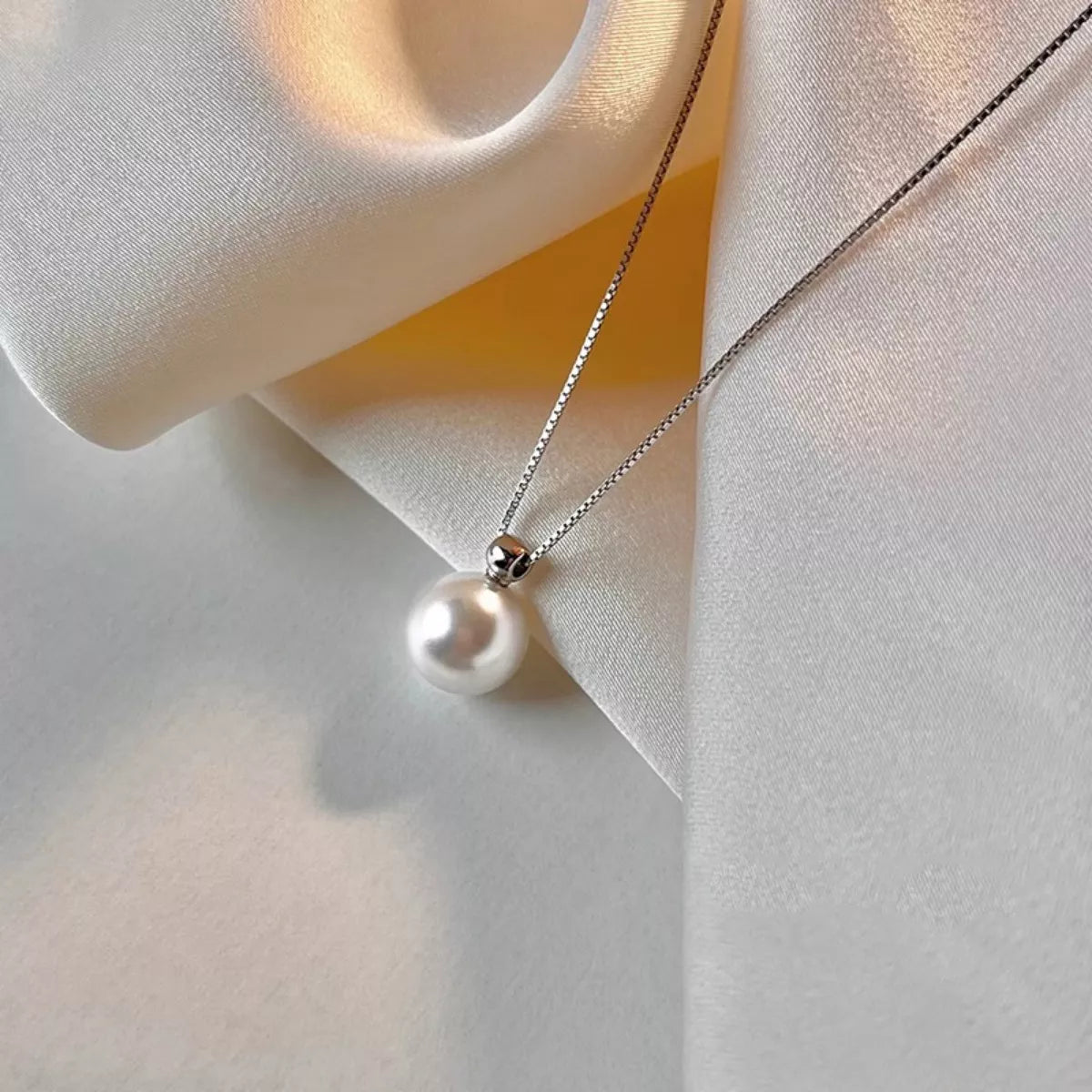 Pearl necklace on a soft fabric background