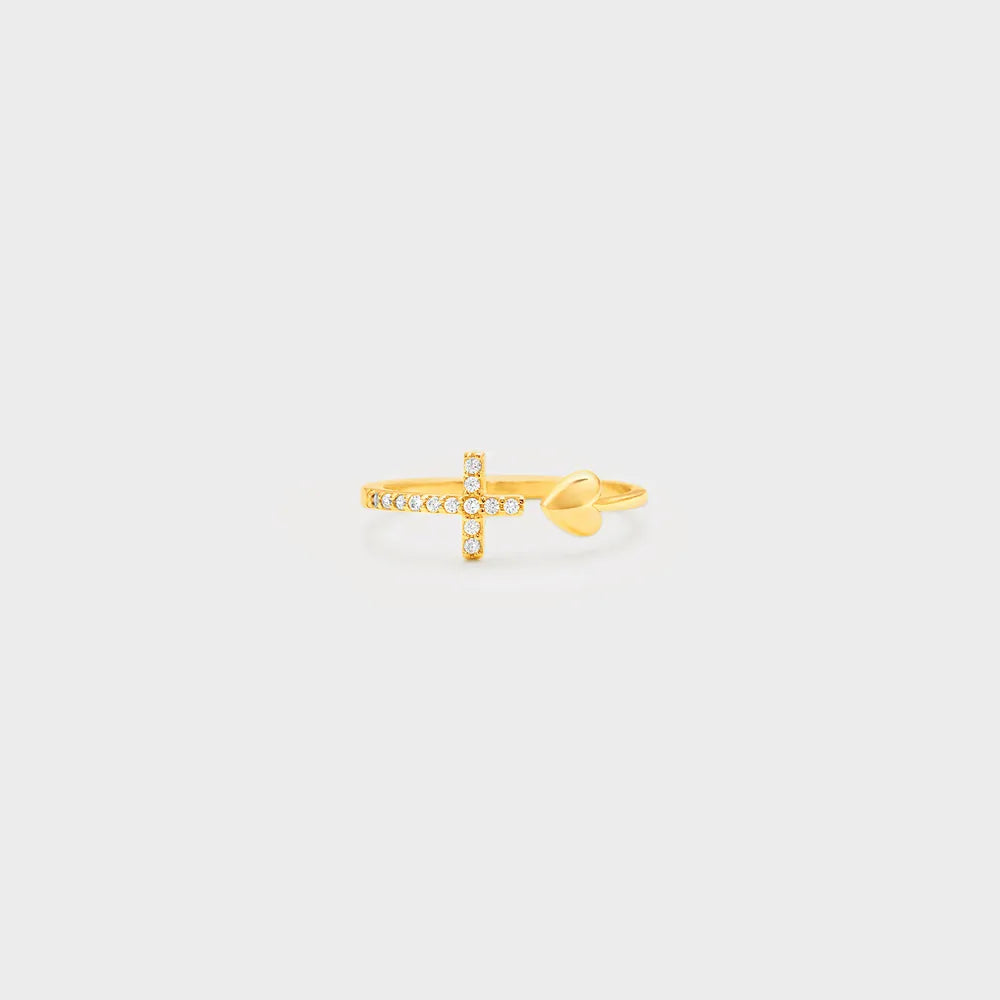 Gold ring with a cross design on a light gray background
