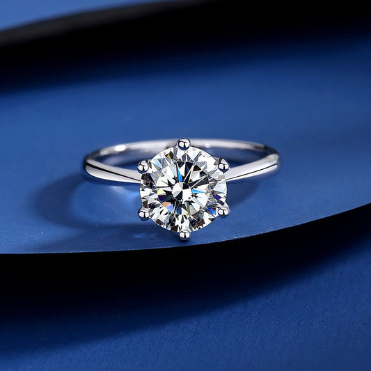 Silver ring with a large diamond on a blue background