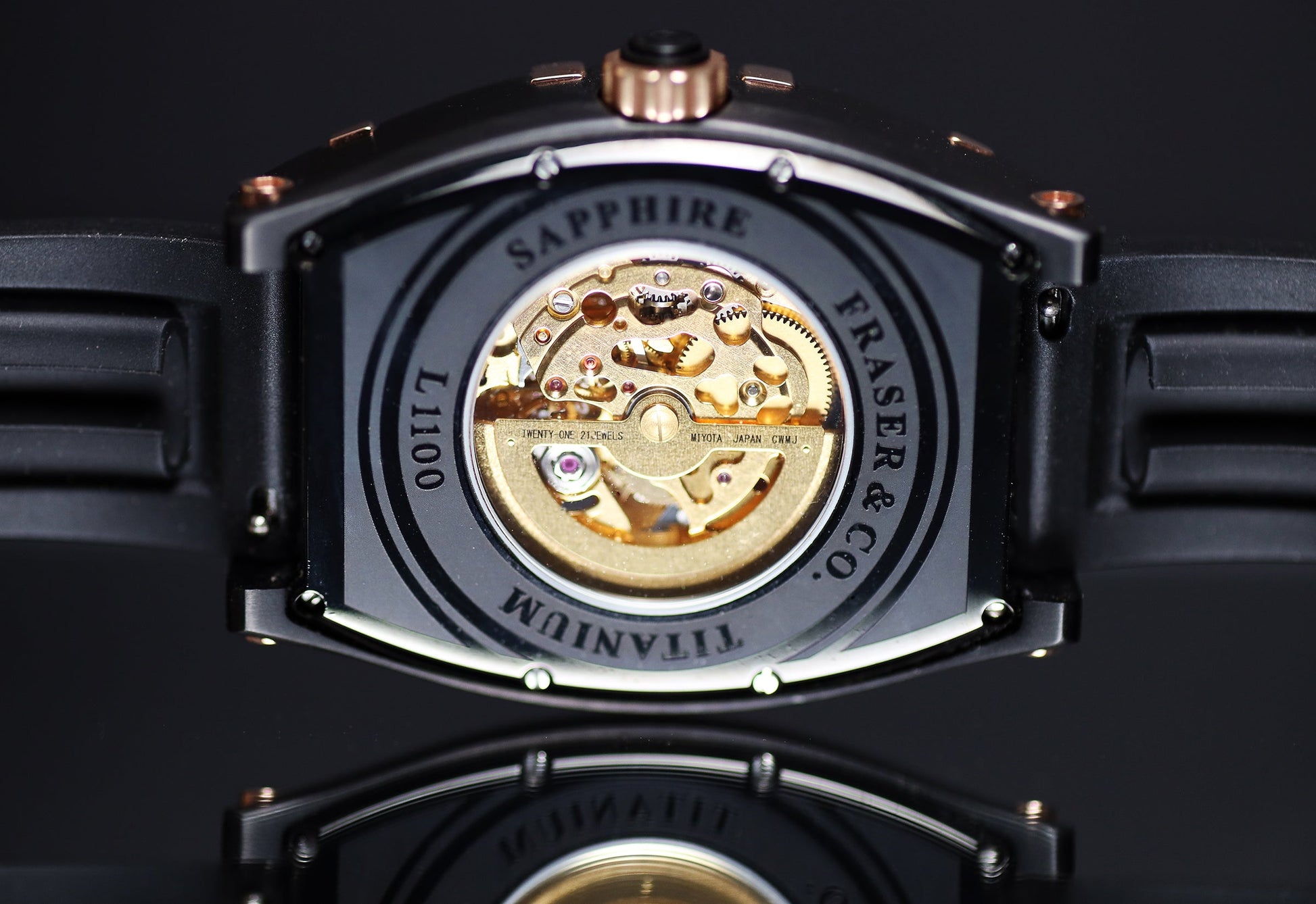 Watch back cover with visible brand name on a dark background