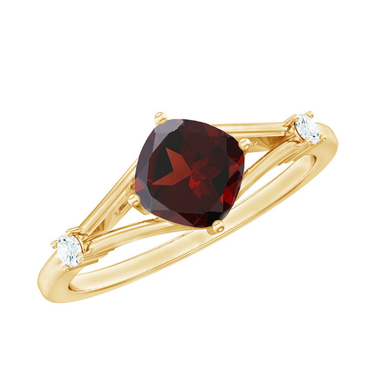 Gold ring with a red gemstone and smaller clear stones on a white background