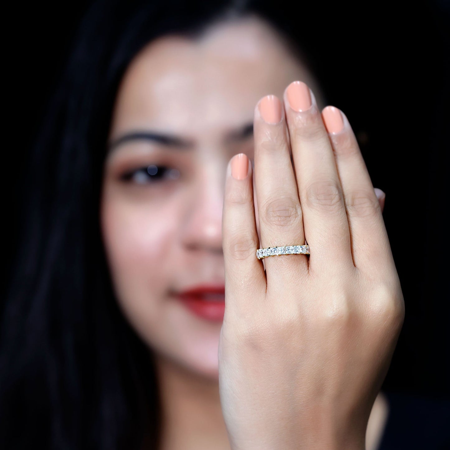 Woman wearing a diamond ring on her hand with a blurred background