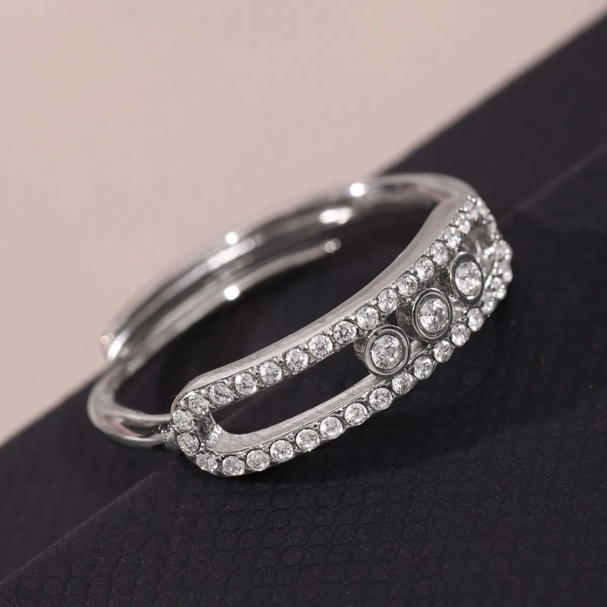 Silver ring with gemstones on a black surface